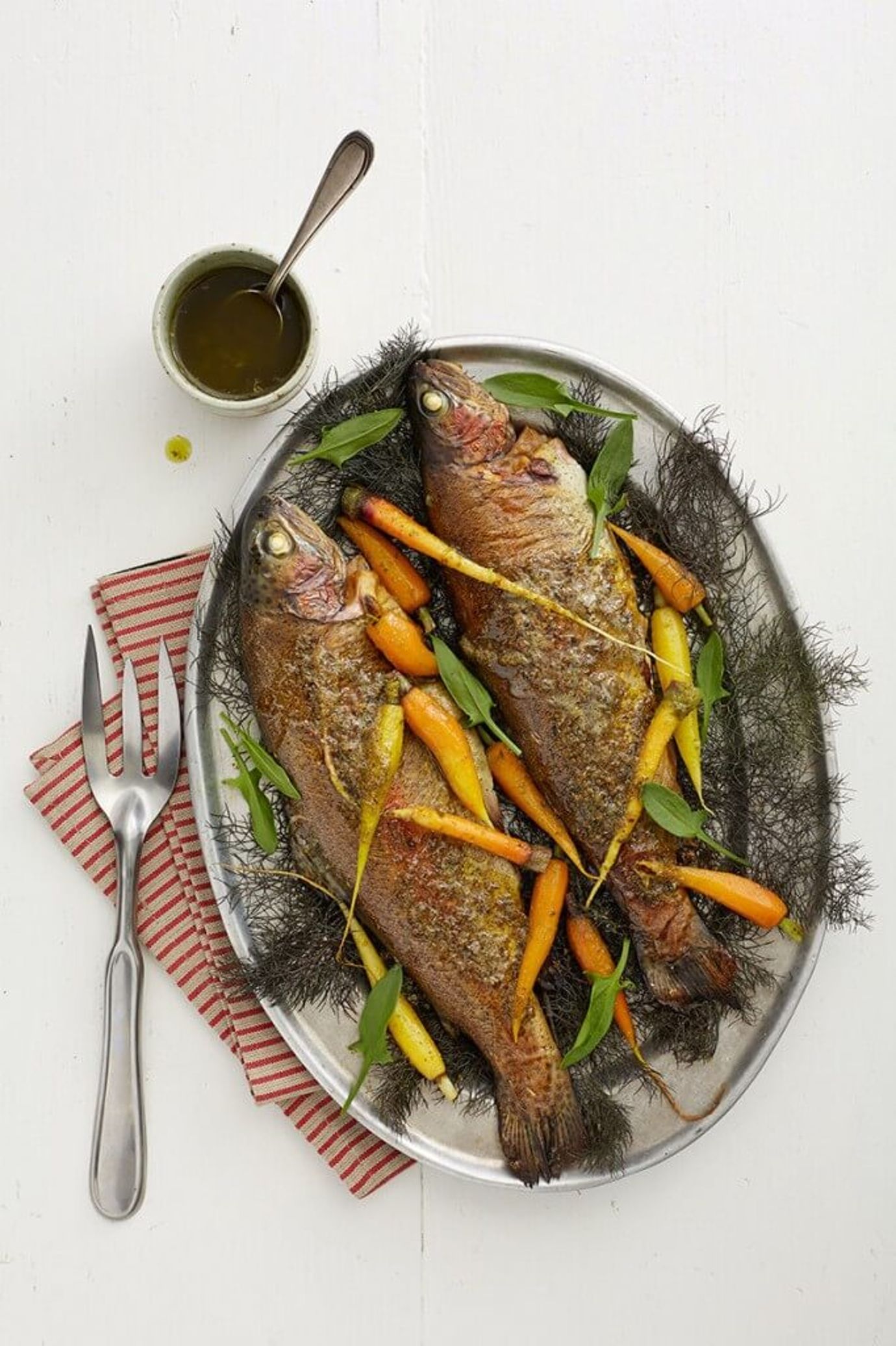 Smoked whole trout with baby rainbow carrots, fennel fronds and caper butter