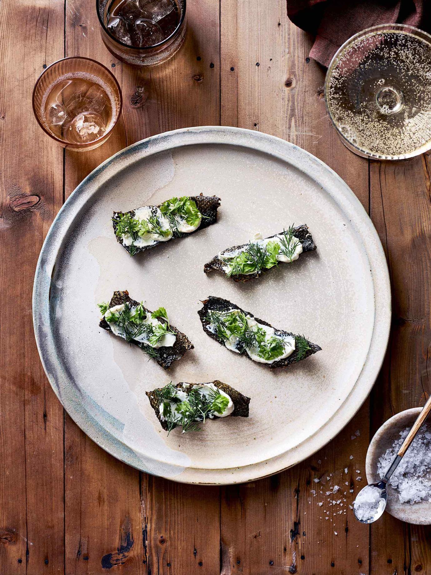 Crispy fish skins with horseradish crème fraiche and pickled herbs