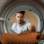 A man putting in clothing in a Miele dryer