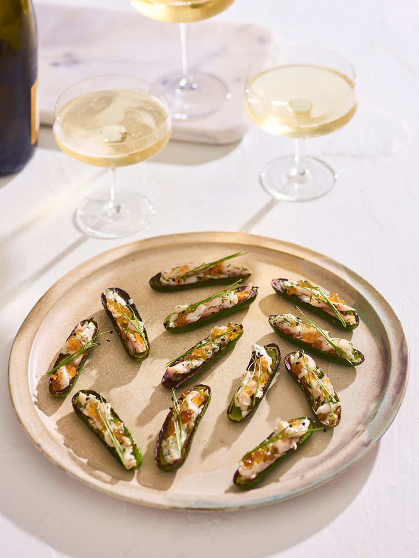 Charred baby cucumbers with confit kingfish and honey chilli pearls