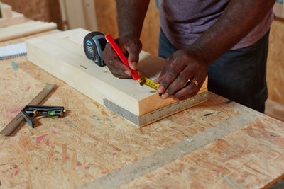 Measuring wood with tape measure