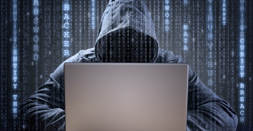 hacker wearing a hood on a laptop