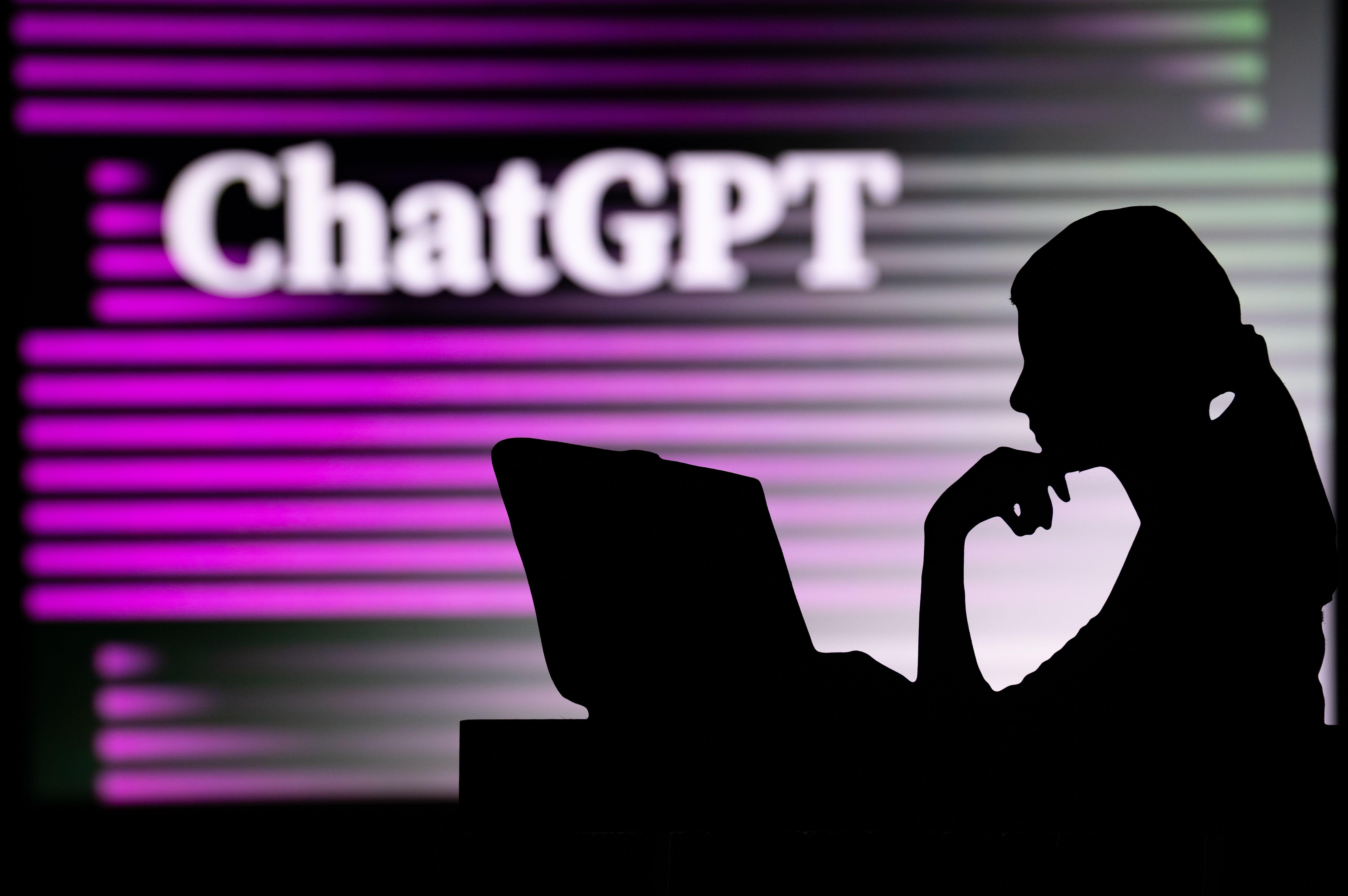 person's silhouette against a glowing wall that says ChatGPT