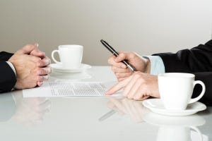 businessmen signing contracts at a table