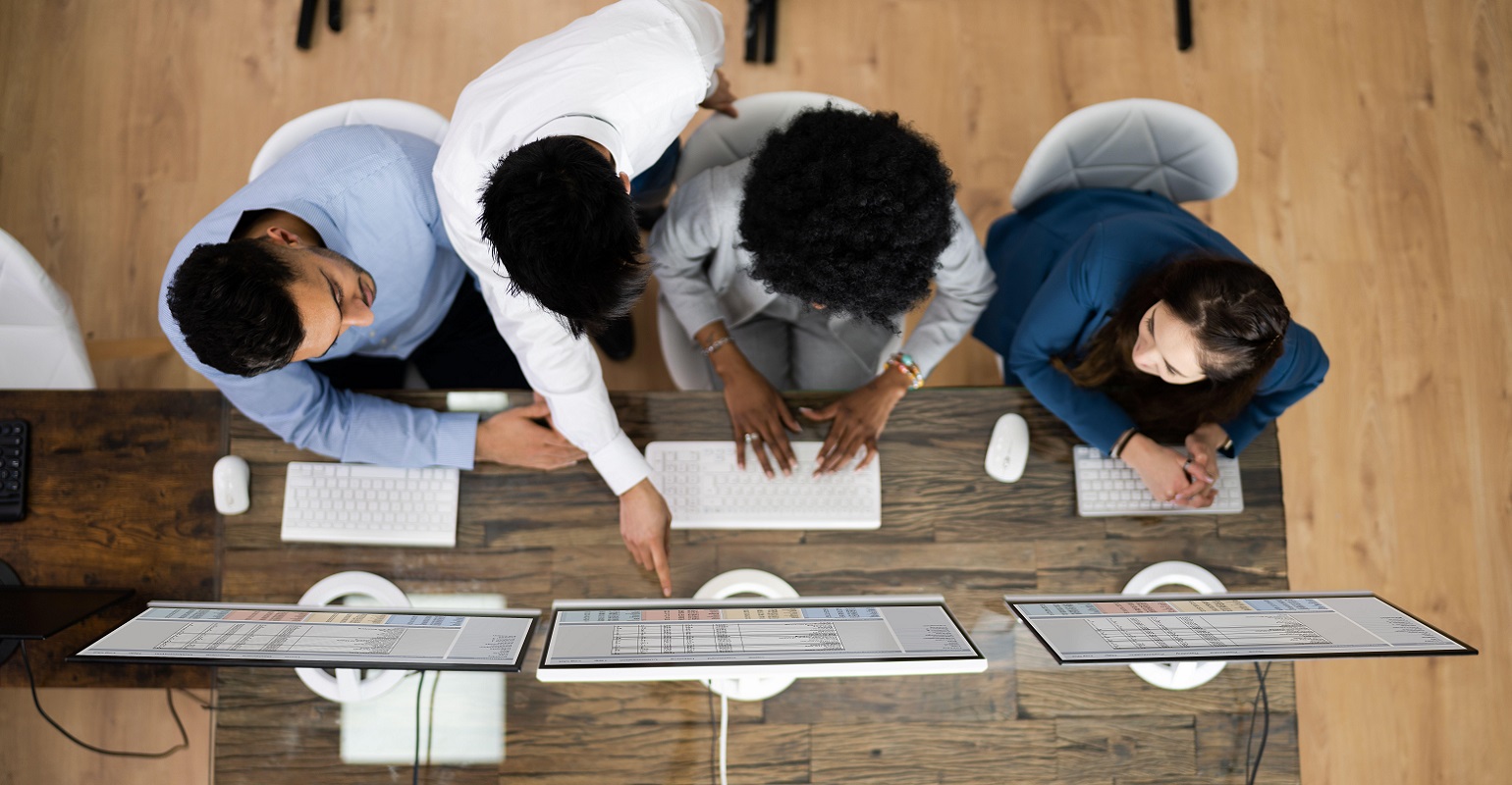 team standing around a laptop