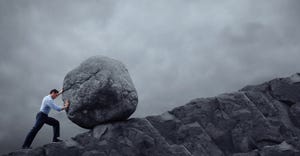 man rolling a rock uphill