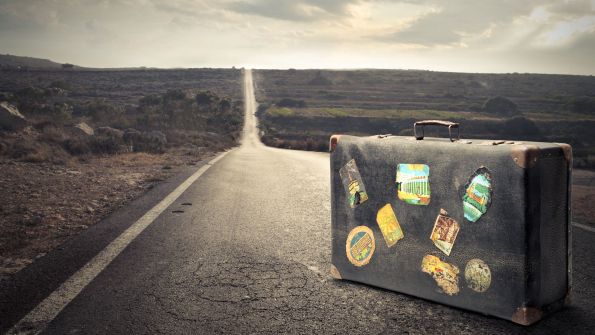Old vintage suitcase in the middle of a road