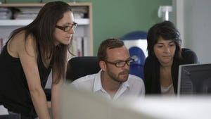 Two women looking a mans computer monitor Two women looking a mans computer monitor