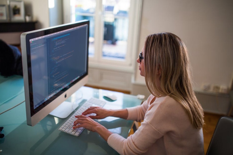 Woman coding at computer