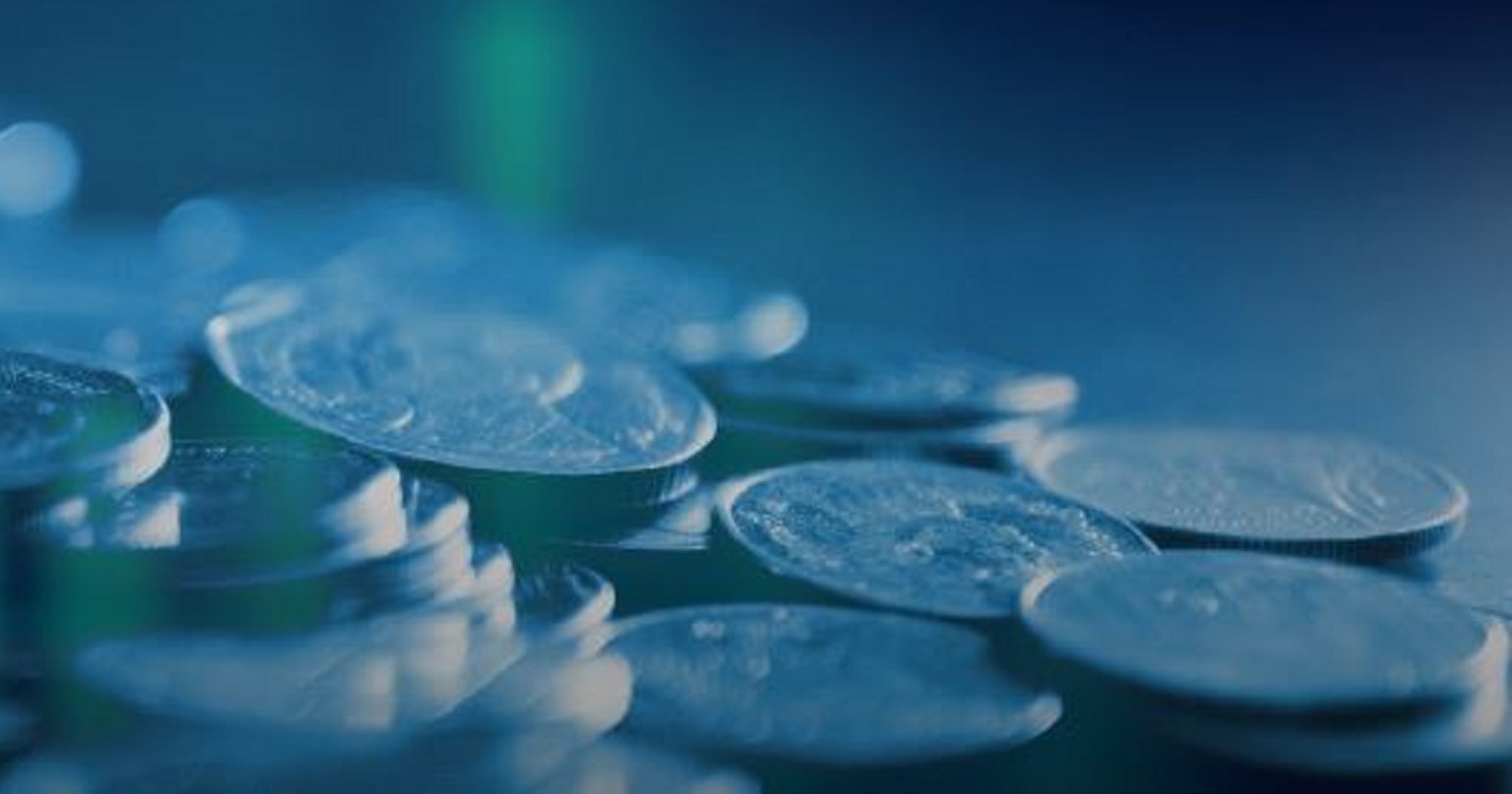 Close-up image of a pile of coins against a blue background