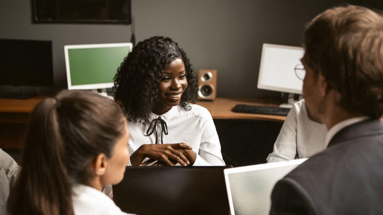 woman leading a meeting around a table with laptops woman leading a meeting around a table with laptops