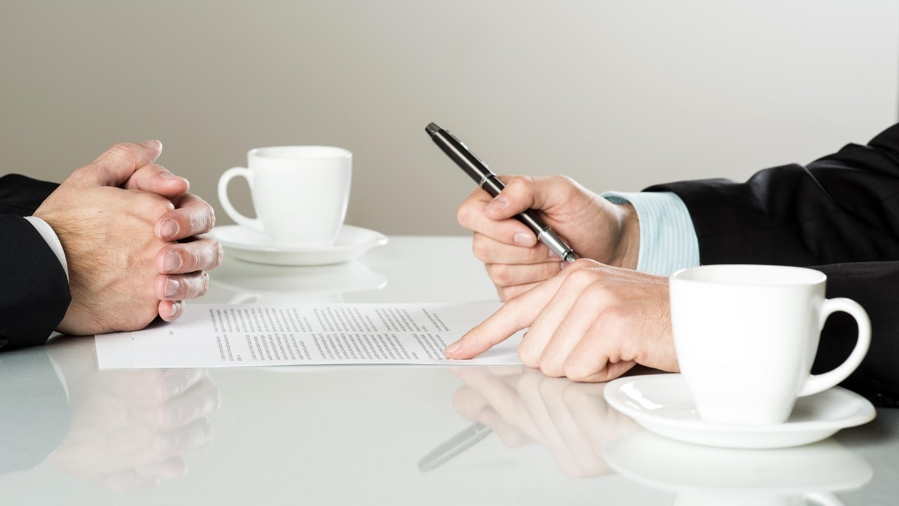 businessmen signing contracts at a table businessmen signing contracts at a table