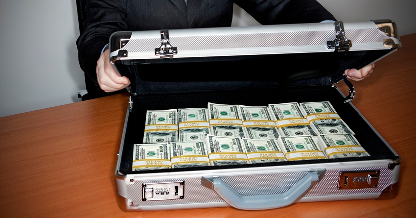 Man holding silver briefcase full of $100 bills