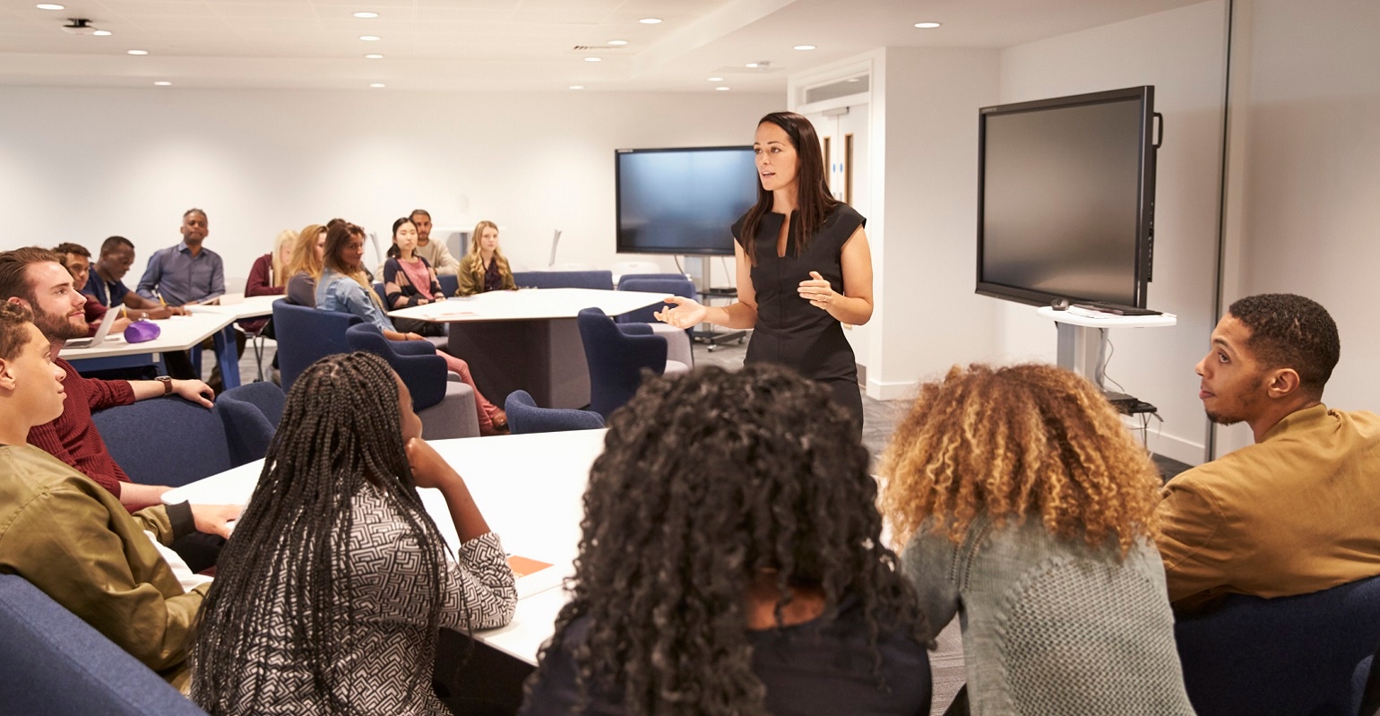 professor addressing university students in a classroom