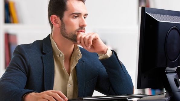 Man looking at computer monitor Man looking at computer monitor