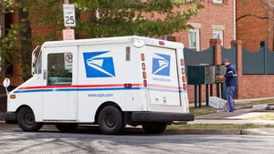 united states mail delivery truck outside of building