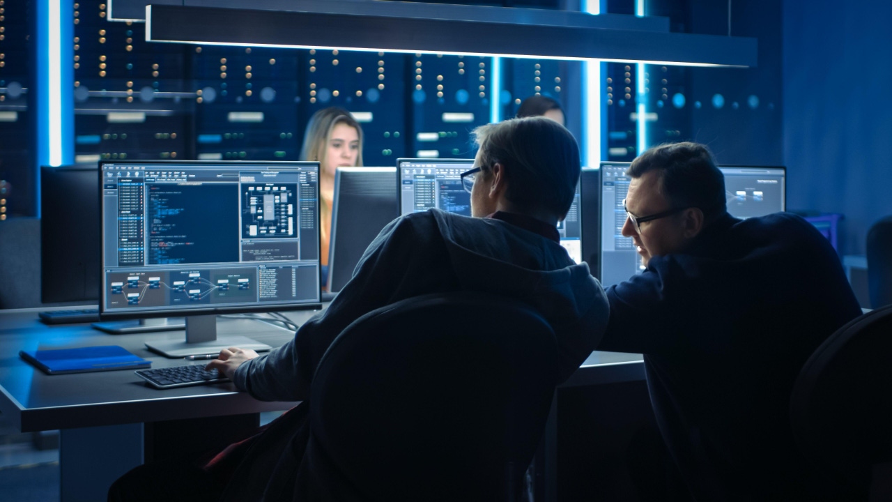employees at desktops in control room employees at desktops in control room