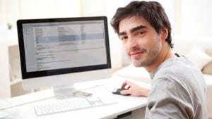 Young man smiling while working on computer