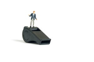 A shrugging business person stands on top of a whistle