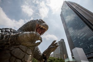 Godzilla faces off against a building.