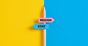 "resign" and "stay" signs attached to a pencil