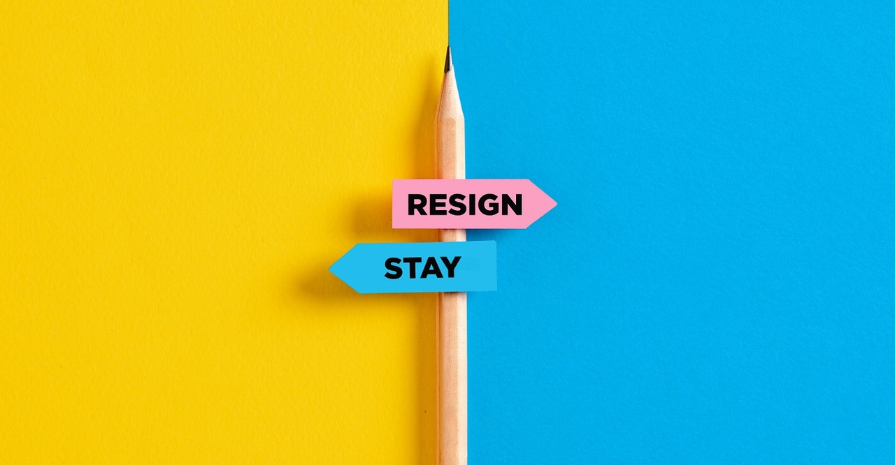 "resign" and "stay" signs attached to a pencil "resign" and "stay" signs attached to a pencil