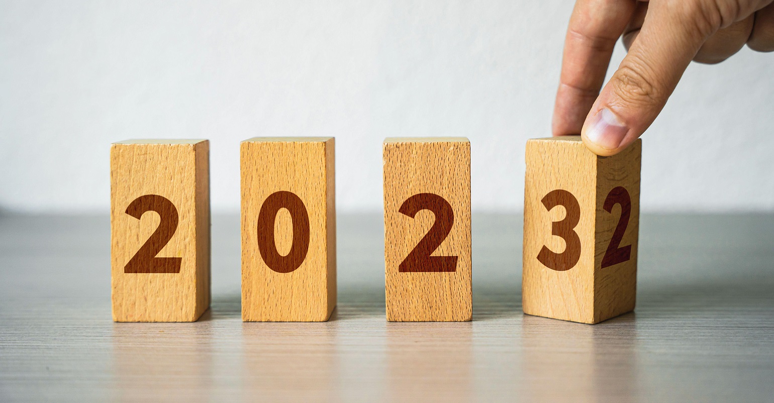 hand turning wood blocks to read 2023