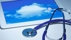 stethoscope on top of a tablet that has a cloud on its screen stethoscope on top of a tablet that has a cloud on its screen