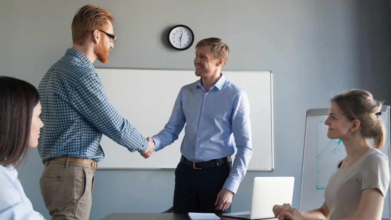 manager shaking hands with a team member manager shaking hands with a team member