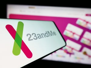 Mobile phone with logo of American biotechnology company 23andMe Inc. in front of business website Mobile phone with logo of American biotechnology company 23andMe Inc. in front of business website