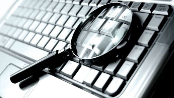 magnifying glass on a laptop keyboard magnifying glass on a laptop keyboard