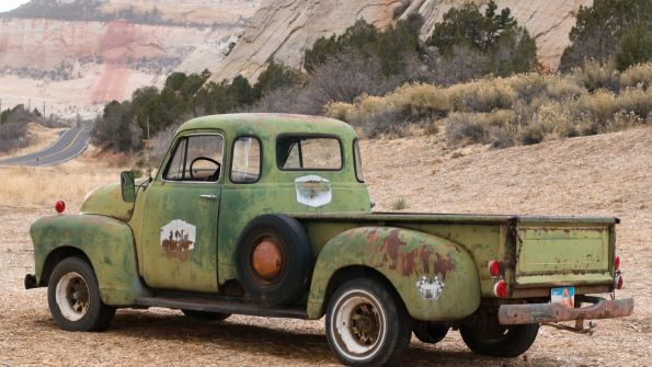 old green pickup by the side of the road