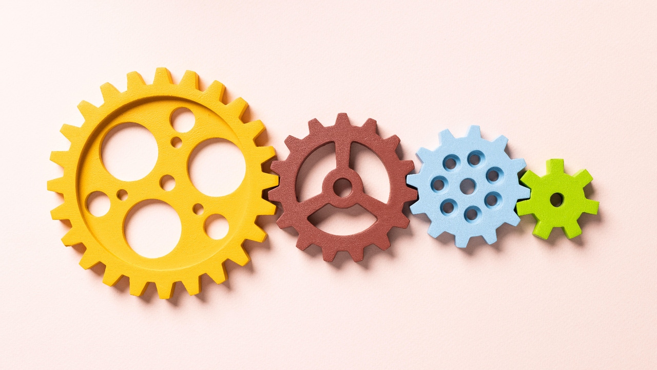 four colorful cogs of different sizes fitted together four colorful cogs of different sizes fitted together