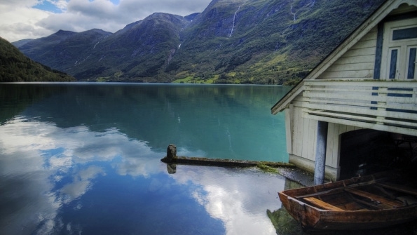 lake and boathouse with mountains in background lake and boathouse with mountains in background
