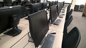 Rows of keyboard and monitors in computer lab