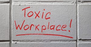 "toxic workplace" written on a wall "toxic workplace" written on a wall