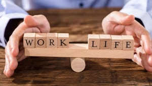 person balancing blocks reading "work" and "life" on a board