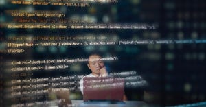 Blurred male computer programmer thinking while programming or coding using a laptop