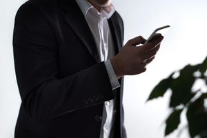 man in suit using a smartphone