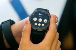 Samsung's smart watch displays laughing and crying emojis.