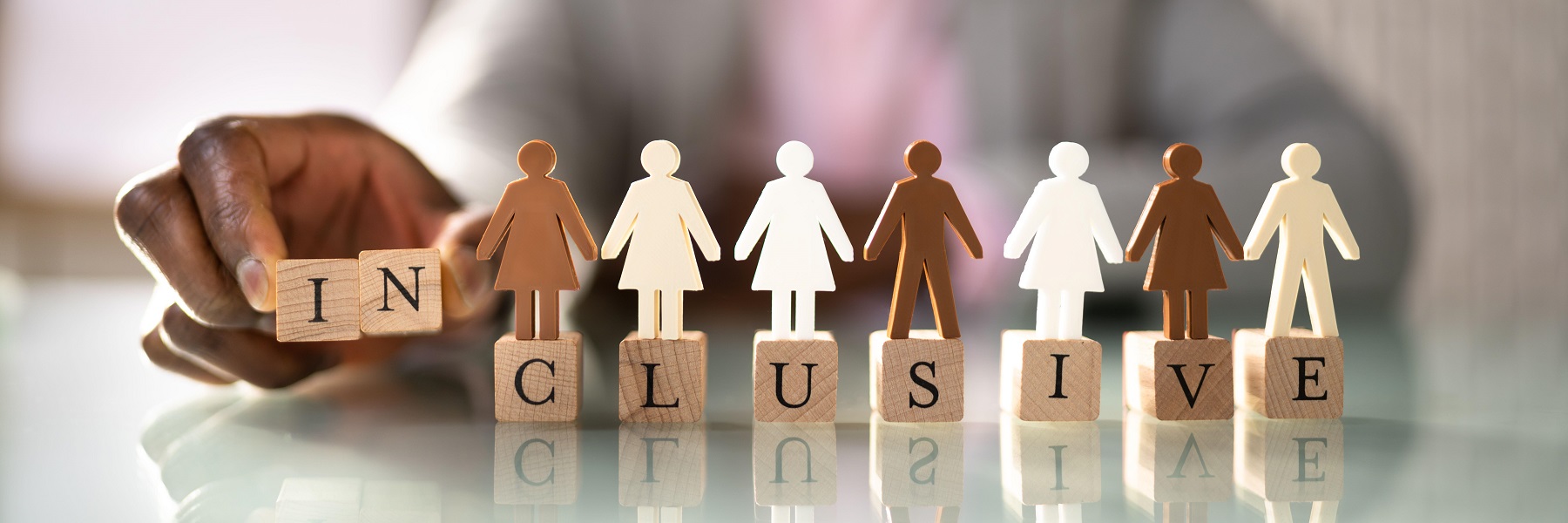 "inclusive" spelled out with blocks with wooden people on top