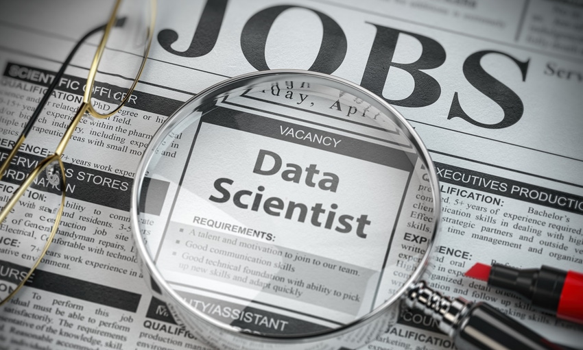Data scientist vacancy in the ad of job search newspaper with loupe