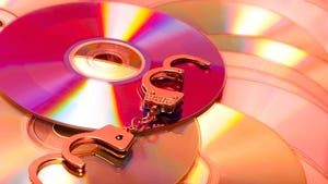 computer software disks with handcuffs laying on top computer software disks with handcuffs laying on top