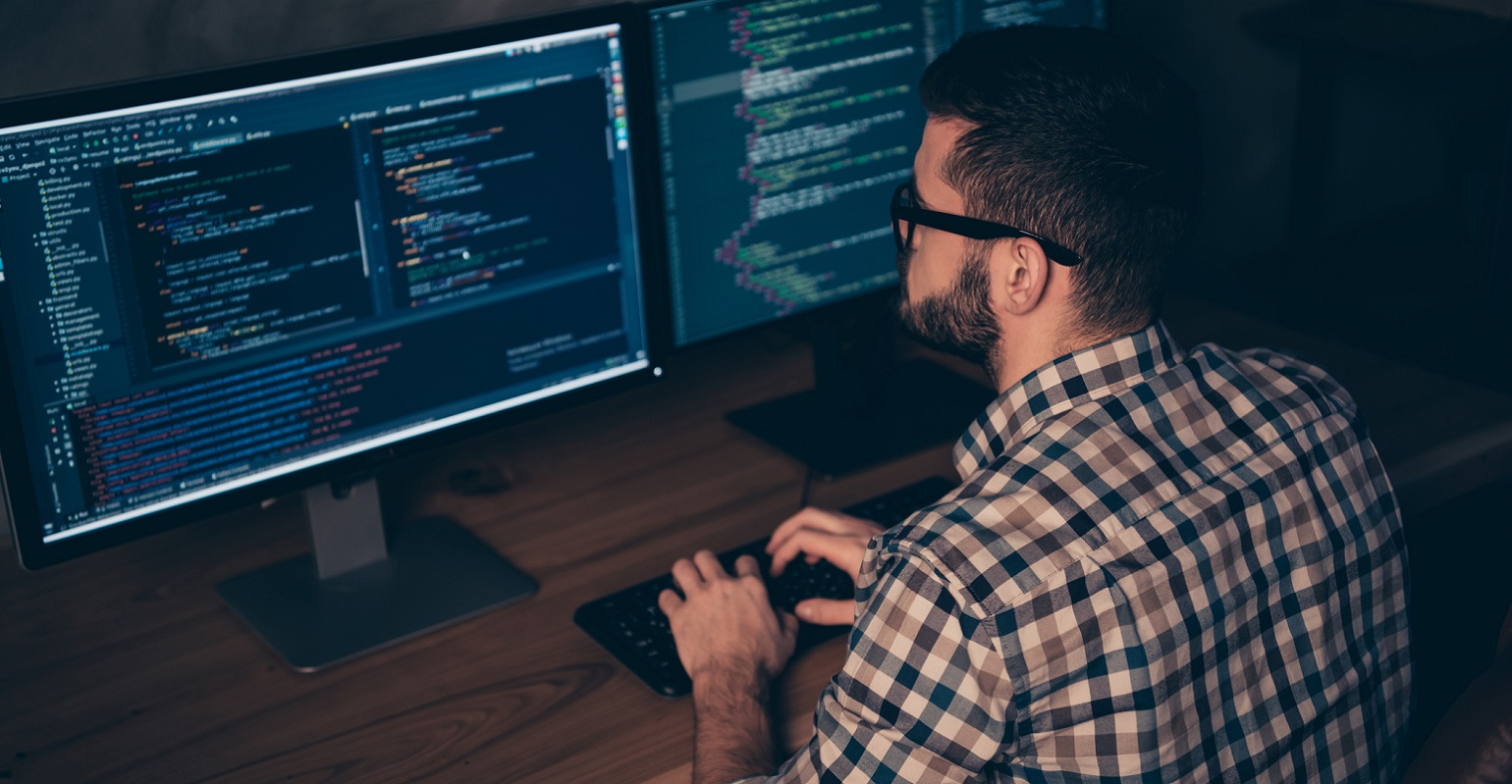 programmer working on two screens