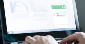 Conceptual image of a robot wearing a headset sitting atop a mobile phone Conceptual image of a robot wearing a headset sitting atop a mobile phone