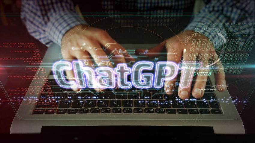 ChatGPT text above a person typing on a laptop