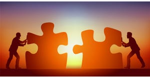businessmen fitting together puzzle pieces