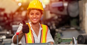 young factory worker gives thumb's up