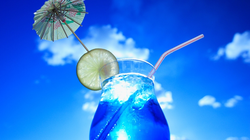 cocktail with drinking straw against blue sky