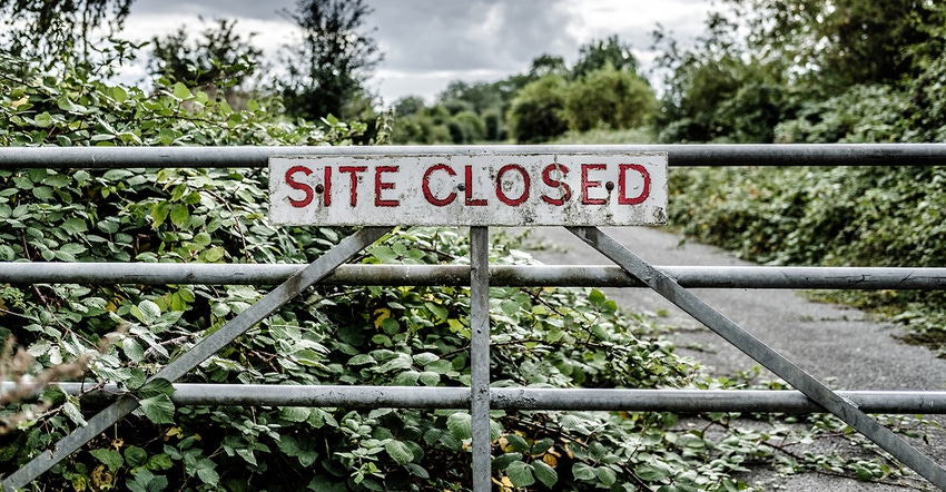 "site closed" sign hanging on gate